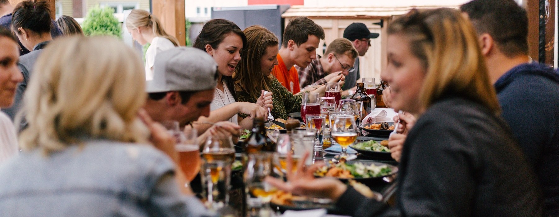a group of people sitting down eating at a restaurant